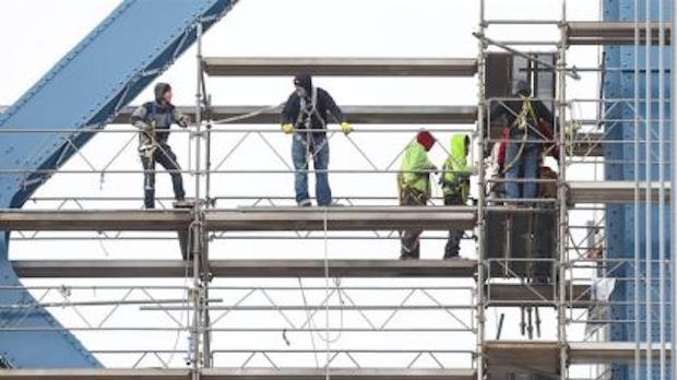 Mannen die veilig werken op steigers