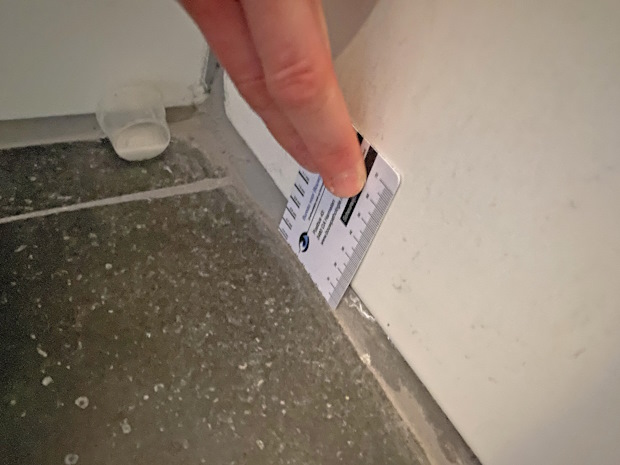 Aan de boven- en onderzijde zijn de tegels met een te grote ruimte vrij gehouden van het plafond en vloer en zijn de grote voegen vervolgens vol gekit.