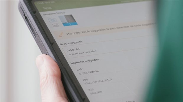 Close-up van tablet waarop AI suggesties voor schilderwerk herstellen worden weergegeven