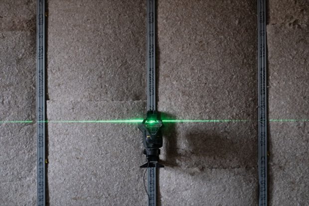 Laserwaterpas bij plaatsen van wandconstructie voor geluid isoleren | BouwTotaal Laserwaterpas bij plaatsen van wandconstructie voor geluid isoleren