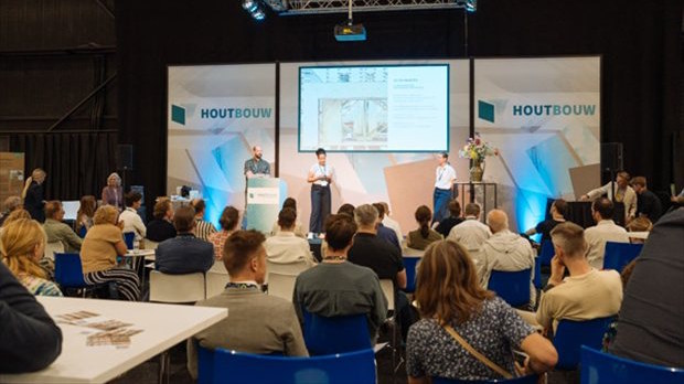 Bezoekers volgen een kennissessie op het podium van vakbeurs HOUTBOUW